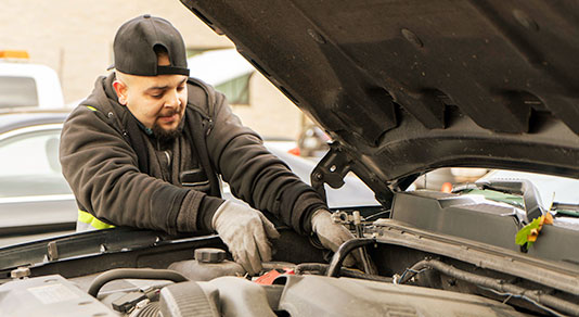 auto mechanic completing car battery check