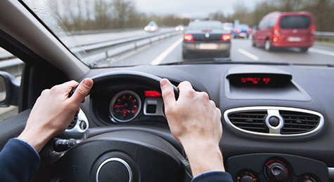 Driving a car on the highway.